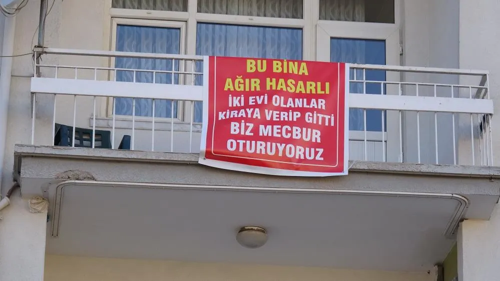 Ağır hasarlı pankartı asılan binayı görenler bir daha bakıyor